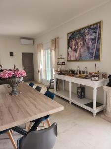 a living room with a table and a painting on the wall at Le Clos Renaissance in Oppède