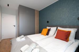 a bedroom with a large white bed with colorful pillows at Echo Nowe Jeżyce in Poznań
