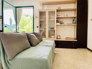 a couch in a living room with a book shelf at Casina di Adele apartment in Volterra
