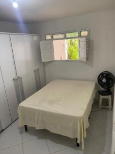 ein kleines Schlafzimmer mit einem Bett und einem Fenster in der Unterkunft Casa para alugar em Campina Grande in Campina Grande