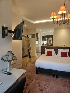 a hotel room with a bed and a television at Hotel Restaurant Charbonnel in Brantôme