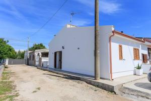 un edificio bianco sul lato di una strada di Villa Alimini - Villetta con veranda Laghi Alimini a Otranto Altre 3 foto