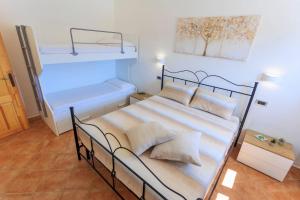 una camera con un letto e due letti a castello di Villa Alimini - Villetta con veranda Laghi Alimini a Otranto