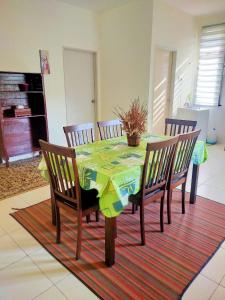 a dining room table with chairs and a tablecloth on it at Khadijah Islamic Homestay Kuantan in Kuantan +1 photo