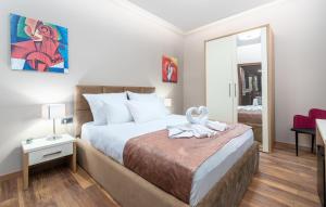 a bedroom with a bed with two towels on it at Hotel Dua Residence in Poreč