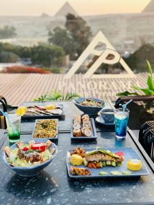 a table with many plates of food on it at PANORAMA view pyramids in Cairo