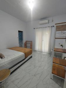 a bedroom with a bed and a table and a window at Stella Villa in Ngurblut