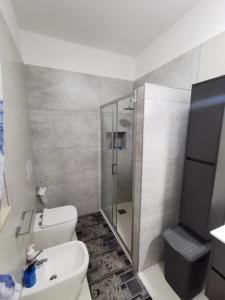a bathroom with a shower and a toilet and a sink at Il Quadrifoglio Appartamento 1 in Massafra +3 photos