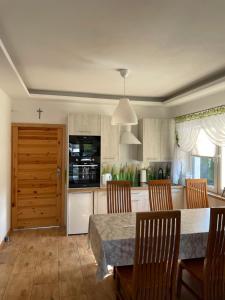 a kitchen with a table and chairs and a kitchen with a counter at Krasnobród Dom Całoroczny in Krasnobród