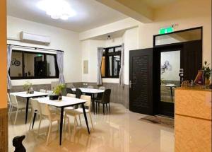 a restaurant with tables and chairs and a cat sitting on the floor at 一點綠民宿 in Jincheng