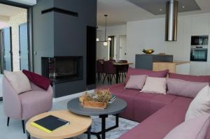 ein Wohnzimmer mit lila Sofas und einem Tisch in der Unterkunft Villa Salsola in Zaton