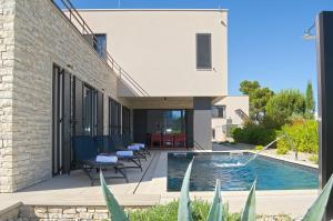 ein Hinterhof mit einem Swimmingpool und einem Haus in der Unterkunft Villa Salsola in Zaton