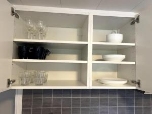 LjungbyhedMysigt boende nära Söderåsen的玻璃杯和盘子的白色橱柜