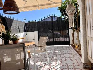 Un patio con mesa y sillas y una valla. en Casa Naranja, en Los Alcázares