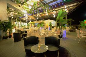 a restaurant with tables and chairs and plants at Lace Boutique Hotel in Johor Bahru