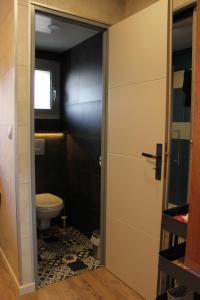 a small bathroom with a toilet and a door at Chaleureux meublé Chessy Proche Disney in Chessy
