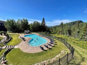 an overhead view of a swimming pool with lounge chairs at Cozy Townhome at Lutsen Mtn - Ski-in, Ski-out, Pool, Hot Tub, Fitness Center, resort amenities galore! in Lutsen