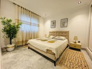 a bedroom with a large bed and a potted plant at Superbe appartement avec piscine in Tunis