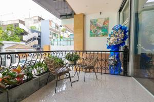 a balcony with chairs and flowers on a building at Ruby Star Hotel Nam Quoc Cang in Ho Chi Minh City