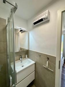 łazienka z umywalką i klimatyzacją na ścianie w obiekcie Enna Apartment B Meerblick perfect location w Medulinie