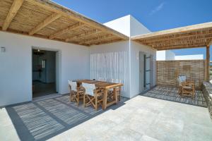 a patio with a wooden table and chairs at Margo Seaview Antiparos in Antiparos
