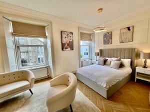 a bedroom with a bed and a chair at Flora in ApartNest Auchterarder in Auchterarder