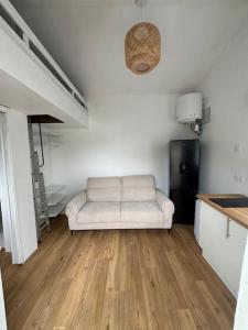 a living room with a white couch in a room at Studio cosy avec piscine à 10 min Hossegor in Saint-Vincent-de-Tyrosse