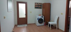 a laundry room with a washing machine and a door at Villa Nathanael in Pogradec