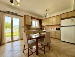 a kitchen with a table and chairs and a refrigerator at Villa Serenity Spilia Garden floor in Argostoli