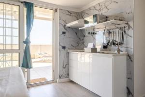 a kitchen with white marble walls and a window at Mezzo Experience Holiday Home Eur in Rome +43 photos