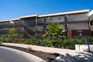 an apartment building with a fence in front of it at Superbe T3 climatisé avec WIFI à 400m de la plage in Vias