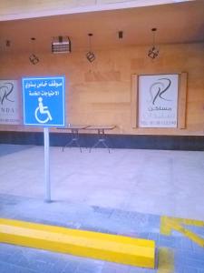 a room with a table and signs on the wall at Sendan Residence in Dammam
