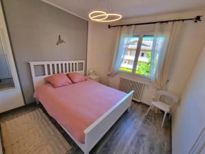une chambre avec un grand lit et une fenêtre dans l'établissement Appartement Cosy entre Lac et Montagne, à Thonon-les-Bains