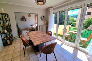 une salle à manger avec une table et des chaises en bois dans l'établissement Appartement Cosy entre Lac et Montagne, à Thonon-les-Bains