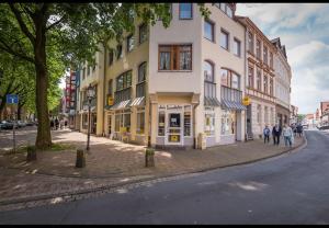 a group of people walking down a street next to a building at Ferienwohnung in Hamelner Innenstadt in Hameln