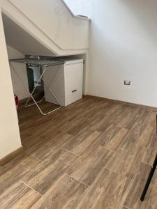 an empty room with a desk and a wooden floor at Casa Marisol in San Giovanni Suèrgiu