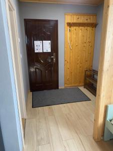 a hallway with a wooden door and a wooden floor at Salt Key House R in Praid