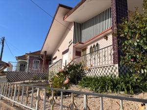 a house with a fence in front of it at Casa dos Neto Santiago in Anadia