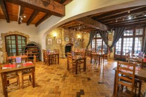 a restaurant with wooden tables and chairs and a fireplace at Eden Auberge in Villefranche-du-Périgord