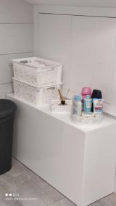 a white kitchen counter with white baskets on it at Apartman Marija in Skradin +5 photos