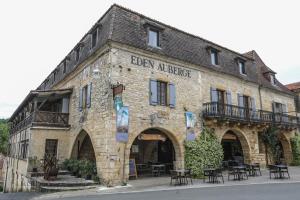 a building with tables and chairs in front of it at Eden Auberge in Villefranche-du-Périgord