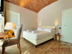 a bedroom with a bed and a desk and a chair at Dimora a Corte in Mathi