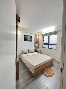 Un dormitorio con una cama grande y una ventana. en Căn hộ 1 phòng ngủ Echo - Entire unit in Ha Long centre- Times Garden Hạ Long, en Ha Long