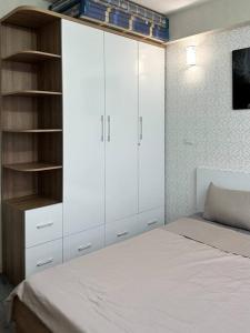 1 dormitorio con armarios blancos y 1 cama blanca en Căn hộ 1 phòng ngủ Echo - Entire unit in Ha Long centre- Times Garden Hạ Long, en Ha Long