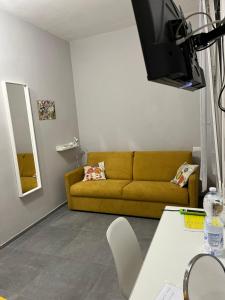 uma sala de estar com um sofá amarelo e um espelho em Bcube - santa Bona Bed & Breakfast em Pisa