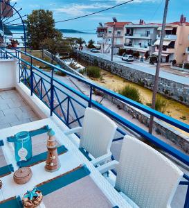 a balcony with a table and chairs and a view of the water at PerAmore Apartment in Nea Peramos