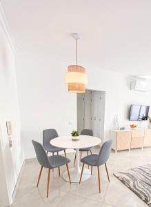 a dining room with a white table and chairs at Casa Joao in Carvoeiro