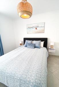 a bedroom with a bed with a blue comforter at Casa Joao in Carvoeiro +18 photos