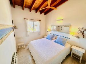 a bedroom with a white bed with blue pillows at Casa Stefi - Astbury Formentera in Es Arenals