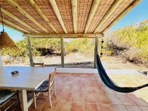 a hammock on a patio with a table and chairs at Casa Stefi - Astbury Formentera in Es Arenals